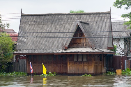 Flooded teak house along a canal in Bangkok during the monsoon season.のeditorial素材