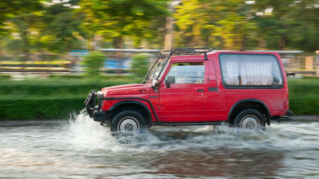 BANGKOK, THAILAND - NOVEMBER 6: Small SUV driving down a flooded street during the worst flooding in...