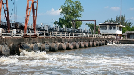 Flood wall with pump outlets where water is pumped from the canals out to the sea in Samut Prakan provins, Thailandのeditorial素材