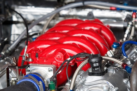 Red top of V8 racing car engine. Shallow depth of field.