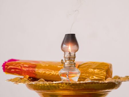Oil lamp and joss sticks during traditional funeral ceremony at a Buddhist temple in Thailand. Shallow depth of field with the lamp in focus.の写真素材