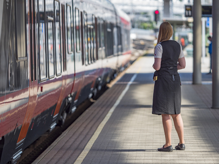 Oslo - June 15, 2017: Female railway staff and one of the popular Stadler Flirt Local Trains at Oslo Central Station in Oslo, Norway. These fast and comfortable trains have become increasingly popular with travellers.のeditorial素材