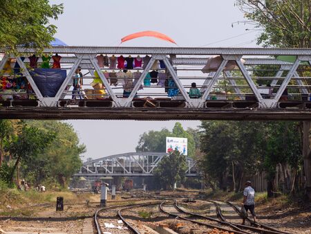 Yangon, Myanmar - January 22, 2014: Fashion shop on a bridge over the railway tracks in Yangon. Myanmar has an extensive railway network, but trains are mostly old and worn out.のeditorial素材