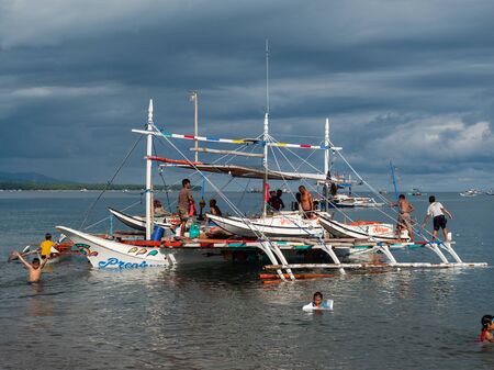 Kiamba, The Philippines - May 31, 2019: Outrigger tuna fishing boat being made ready to leave at the beach in Kiamba, Sarangani Province in the Philippines. The onboard dinghies are being used for pole and line fishing of tuna.のeditorial素材