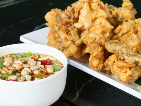 Japanese tempura style deep fried mushrooms with Thai som tam style hot sauce. The mild tempura batter and hot, sweet and sour Thai sauce compliment each other. Shallow depth of field.の写真素材