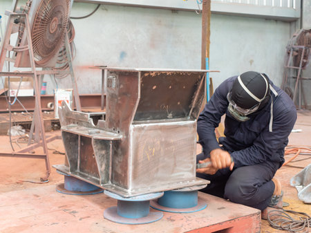 Hammer mill being prepared for spray painting at industrial paint shop.の写真素材