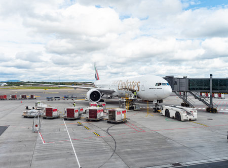 Gardermoen, Norway - August 22, 2022: Emirates Boeing 777-300ER at a gate of Oslo Airport, Gardermoen, being loaded with cargo and luggage containers before departure.のeditorial素材