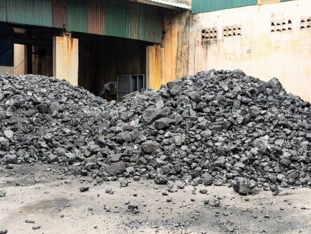 Piles of coal at the backyard of a factory in Vietnam where it's being used as fuel for production of steam for various industrial processes.の写真素材