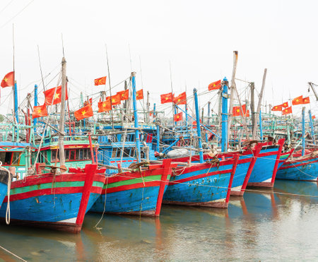 Fishing boats moored at low tide on Song Lang Giang, Lang Giang River, in Quong Nham, Vietnamの写真素材