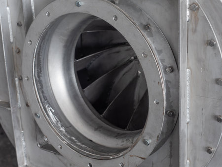 Closeup detail of stainless steel centrifugal fan during production at an industrial workshop. Shallow depth of field with the right side of the fan housing in focus.の写真素材