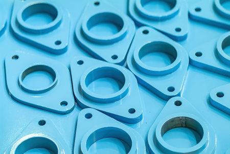Metal parts for piping painted blue at an industrial paint shop. Shallow depth of field with the nearest components in focus.の写真素材