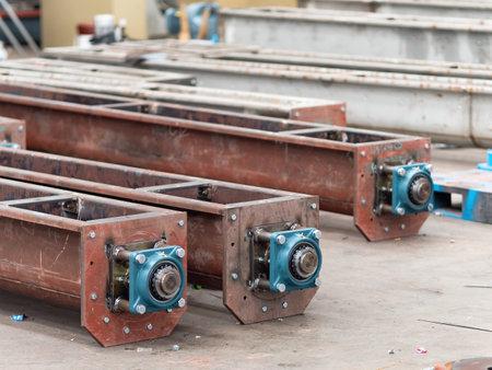 Screw conveyor with ball bearings during manufacturing at an industrial workshop. Shallow depth of field with the two nearest conveyors in focus.の写真素材
