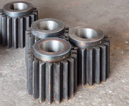Large, heavy duty cogwheels for industrial applications on a concrete factory floor.の写真素材