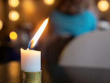 White candle burning. Very shallow depth of field, with only the flame and wick in focus.の写真素材
