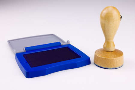 A round rubber stamp with wooden handle with an open blue stamp padの写真素材