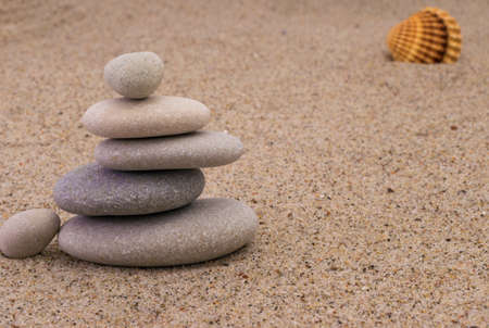 Spa stones with shellfish on sandの写真素材