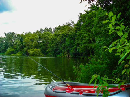 Fishing off an inflatable rubber dinghy on a tranquil lake. Nature background.の写真素材