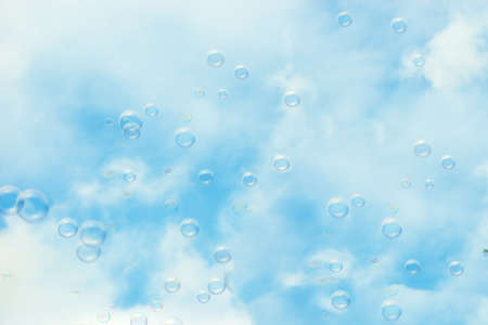 Soap bubbles floating in a blue skybackgroundの写真素材
