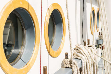 Belayingl pins and window or porthole on a tall shipの写真素材