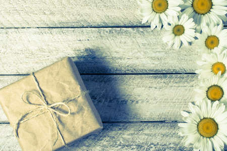 gift box with chamomile on wooden backgroundの写真素材
