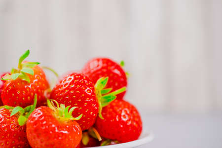strawberries in bowl on wooden table with low key and copy spaceの写真素材