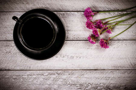 flowers and coffee cup on wooden table with copy space. celebration template concept.の写真素材