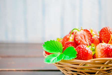 strawberries in bowl on wooden table with low key and copy spaceの写真素材