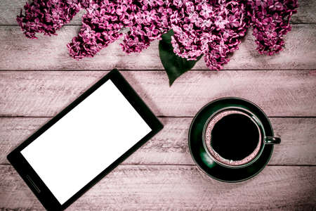 workspace with tablet and coffee cup. lilac on wooden table. top view with copy space. celebration...