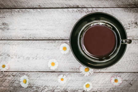 cup of coffee and Chamomile flowers on wooden background. cover, card. copy space.の写真素材
