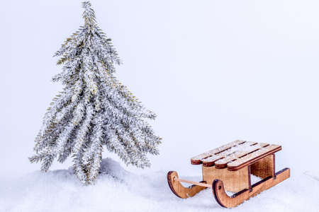 Christmas tree in snow under snowflakes with sledge. Christmas and New Year concept. Christmas greeting card.の写真素材