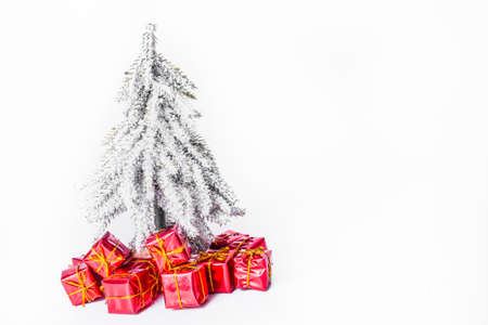 Christmas tree in snow with red xmas gifts and sledge. Christmas and New Year concept. Christmas greeting card.の写真素材