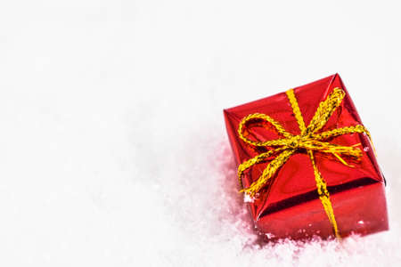 xmas red gift under snowflakes in snow with copy space. Christmas and New Year concept. Christmas...