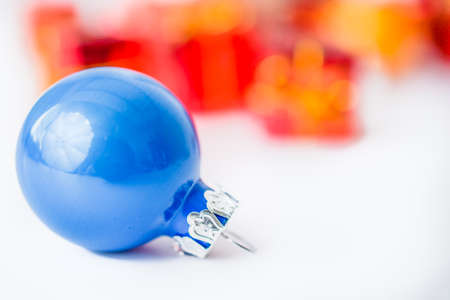 Close-up of blue xmas ball with blurred colorful Christmas decorの写真素材