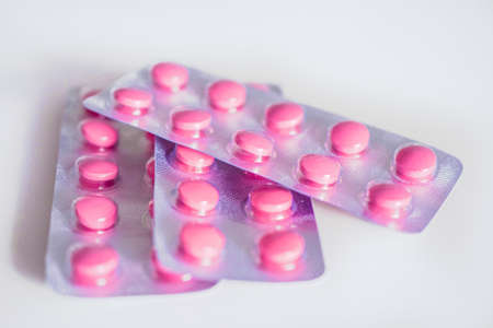 closeup of pink pills in blister on white backgroundの写真素材