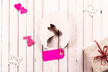 wooden easter rabbit with gift box and blank sale label. Easter decoration with copy space.の写真素材