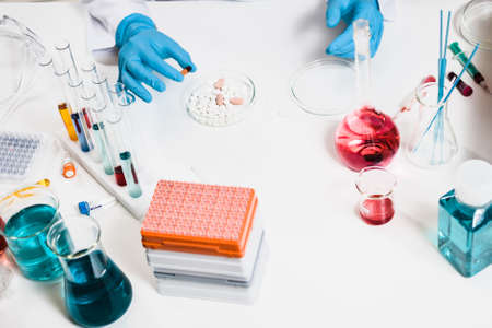 Researcher holds pill in hand in laboratory. drug discovery, pharmacology and biotechnology concept....