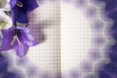 blank note book close-up with spring flowers and copy space on wooden background. summer border template. mock-up floral background. sale, greeting and celebration card concept.の写真素材