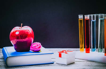 Back to School and Education concept. classroom with book, apple and laboratory chemical test tubes on chalkboard background. school border with copy spaceの写真素材