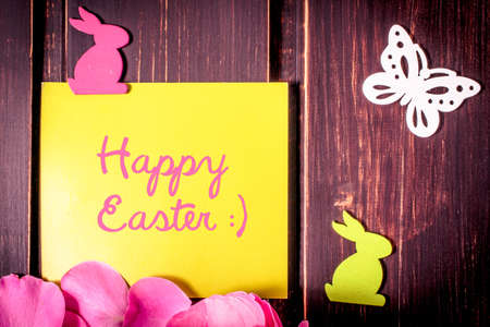 Happy Easter card with rabbits, butterfly and rose leaves on wooden background. easter sale,...
