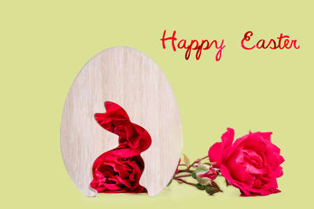 close-up of wooden easter egg with rabbit shape of rose flowers in background. template with copy space. easter concept and easter greeting card.の写真素材