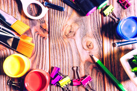 Back to school. school and office supplies. education and school border concept. art template with free and copy space. scissors, paint brushes, acrylic color, paper clips on wooden background.の写真素材