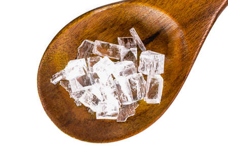 Closeup of rock salt in spoon on rustic wooden background