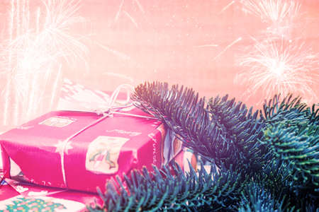 Christmas gift box with fir tree branch on wooden background. Xmas presents concept with copy space. Christmas border or greeting cardの写真素材