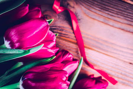 tulips on wooden background with free space. Mothers Day background. Greeting card and spring border...