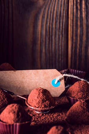 Chocolate truffles and sale tag, macro. delicious homemade truffle with dark chocolate and cocoa powder.の写真素材