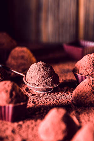 Chocolate truffles on wooden background, macro. delicious homemade truffle with dark chocolate and...