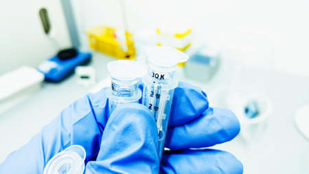Hand in blue glove holding the tubes with DNA samples.の写真素材
