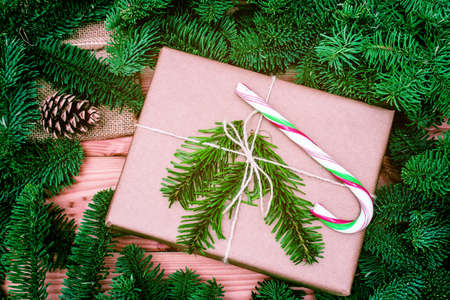 christmas gift. Xmas gift with candy on wooden background. christmas presents with Fir tree branches.の写真素材