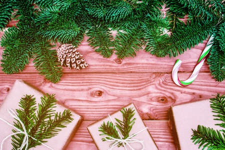 christmas gift. Xmas gift with candy on wooden background. christmas presents with Fir tree branches. Xmas greeting card and border with copy spaceの写真素材