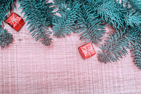Happy Christmas. Christmas gift on wooden background. Xmas gifts and presents with fir tree branches. Xmas greeting card and border with copy spaceの写真素材